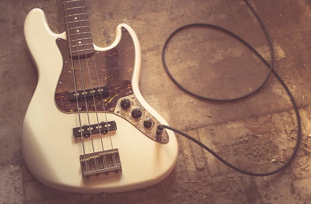 Vintage electric guitar with cable on floor